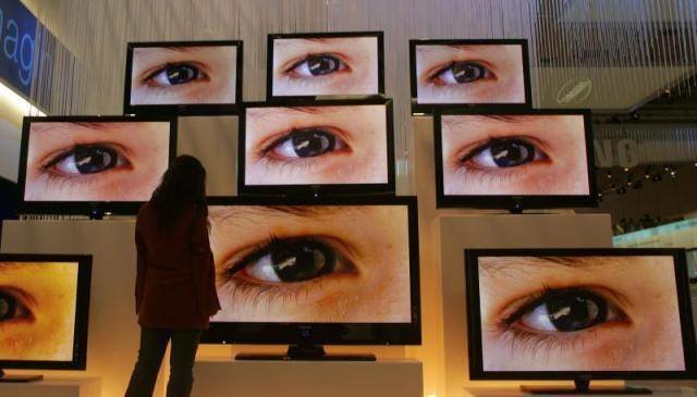 Una mujer delante de unos televisores. A woman stands in front of flat screens at an exhibition stand of the IFA 2007 consumer electronics fair in Berlin August 30, 2007. The fair opens August 31 with 1,202 exhibitors from 40 countries and runs till September 5. REUTERS/Hannibal Hanschke (GERMANY) GERMANY/